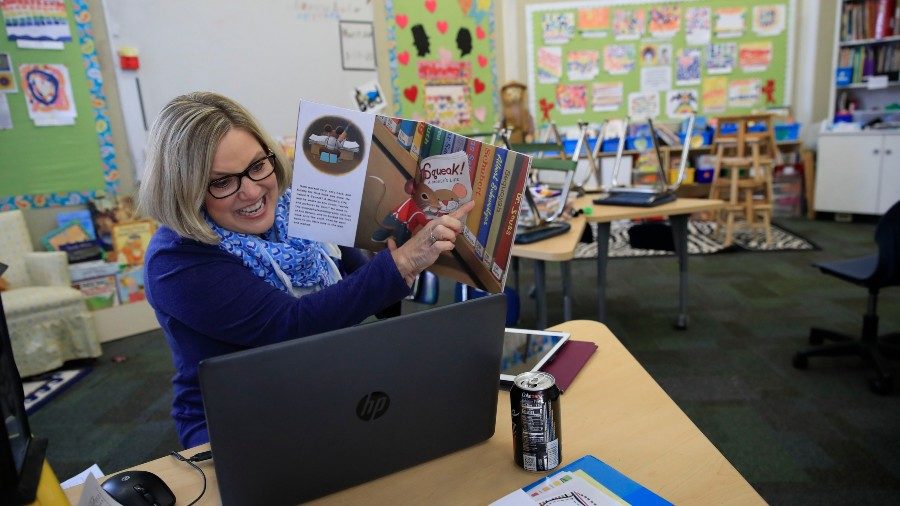teacher explaining the book in front the computer
