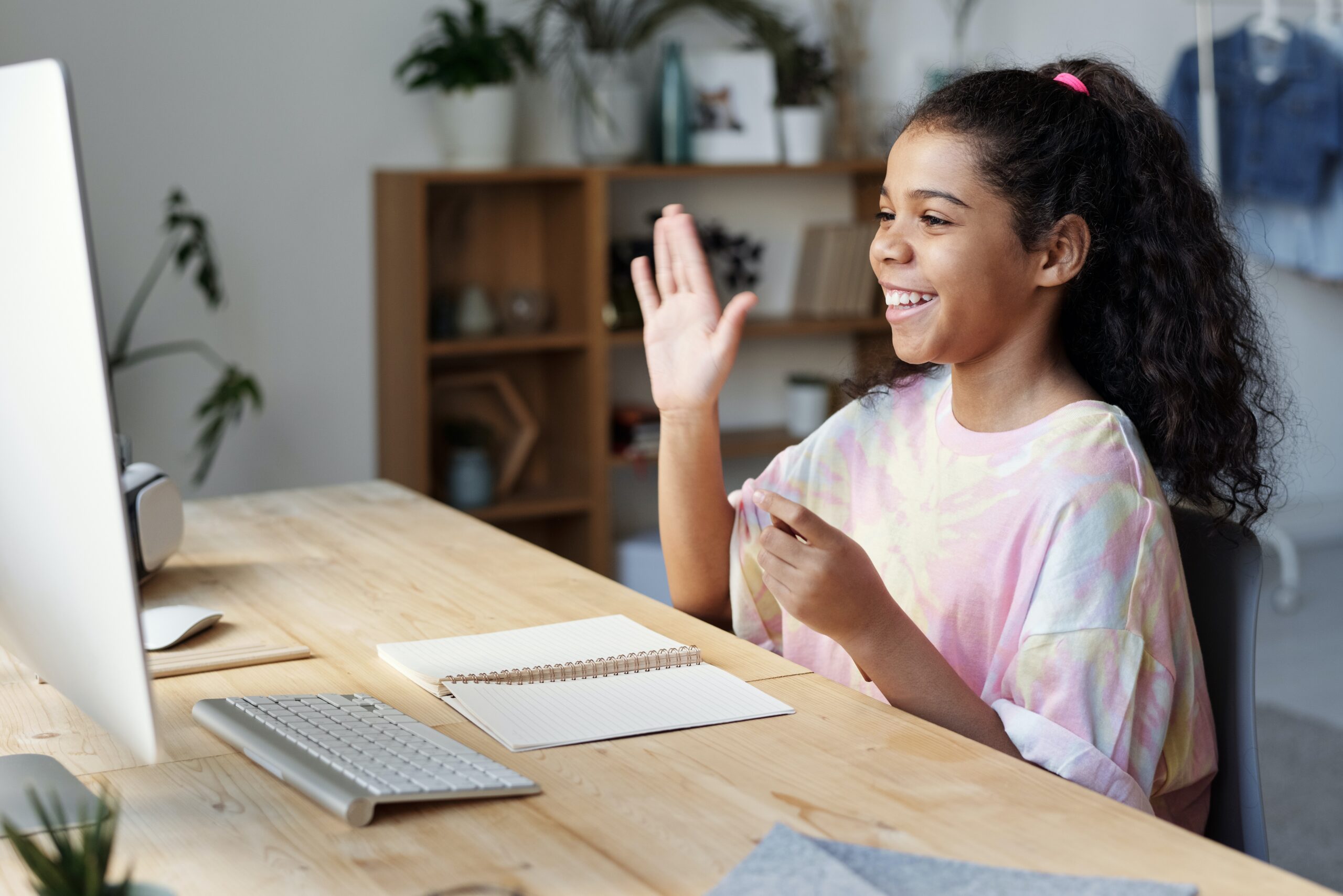 Girl with a pink blouse in front of a computer