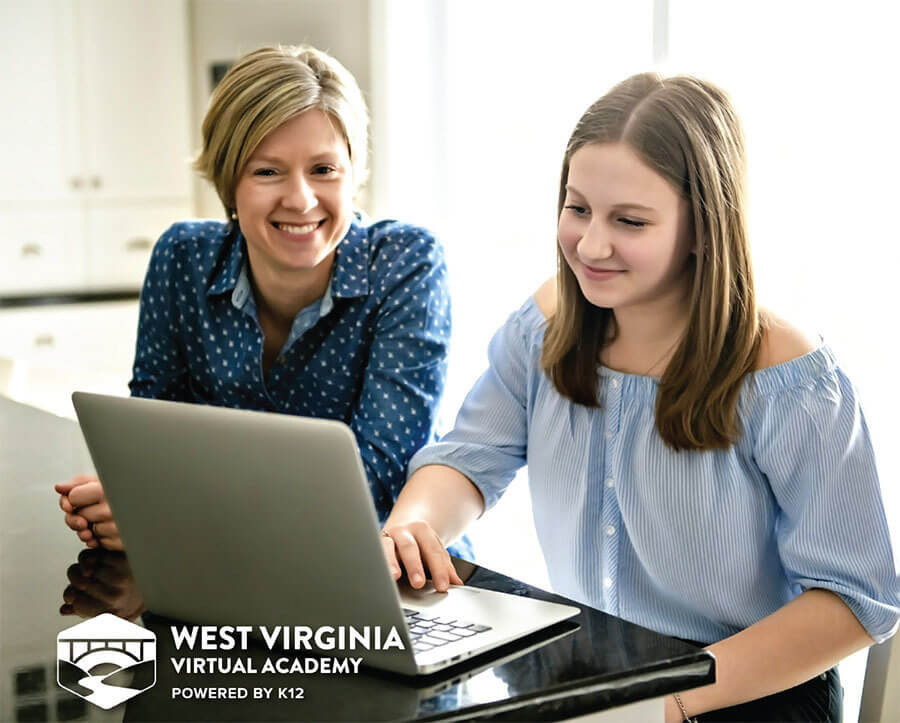 woman and girl looking the computer and smiling 